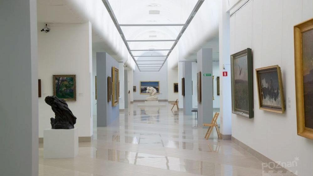 The spacious, brightly lit museum hall with numerous pictures on the walls