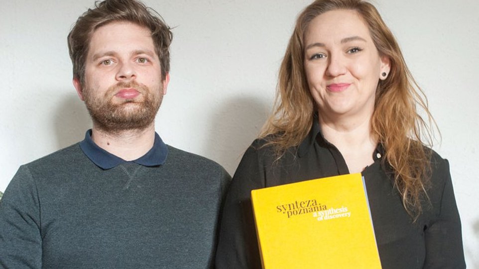 Photo of the authors of the book, who are looking into the camera. THe woman brings the book in her hands.