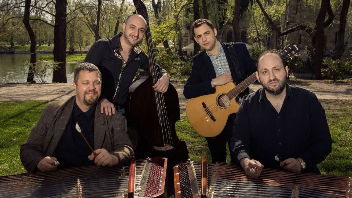 Photo of the band - four man standing by their musical instruments