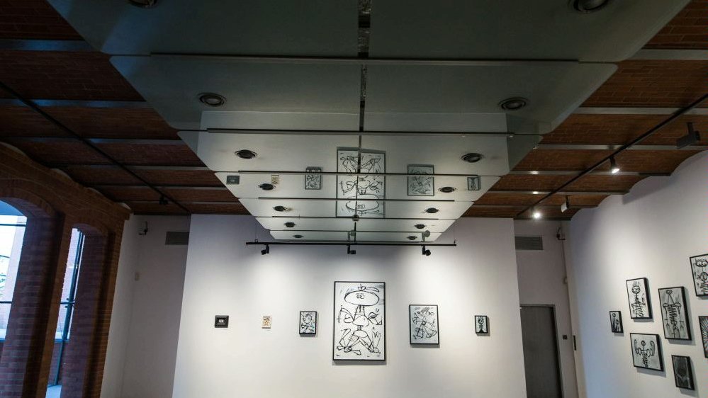 Photo of the exhibition room with a few black and white pictures on the walls.