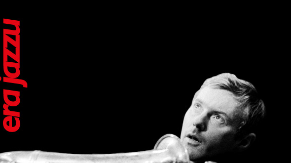 Concert poster - black and white photo of the artist on black background. At the top of the poster - information about the concert.