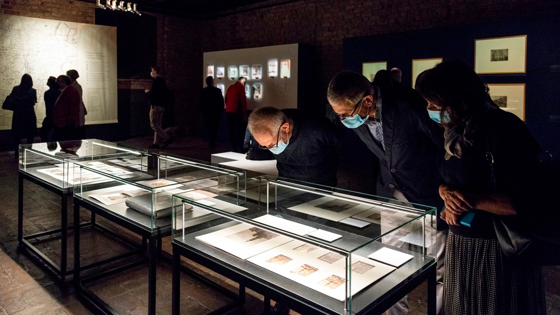 Photo of exhibition visitors - several people watching the exhibits.