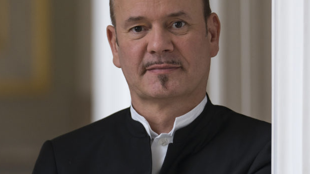 Photo of the conduktor Frank Strobel - a man in a suit with his arms folded