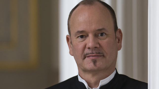 Photo of the conduktor Frank Strobel - a man in a suit with his arms folded