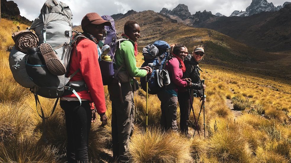 Picture from the movie - a group of women with rucksacks walking in the mountains.