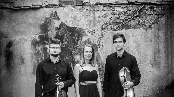 Black and white photo of the Trio - two men with their musical instruments and a woman between them.