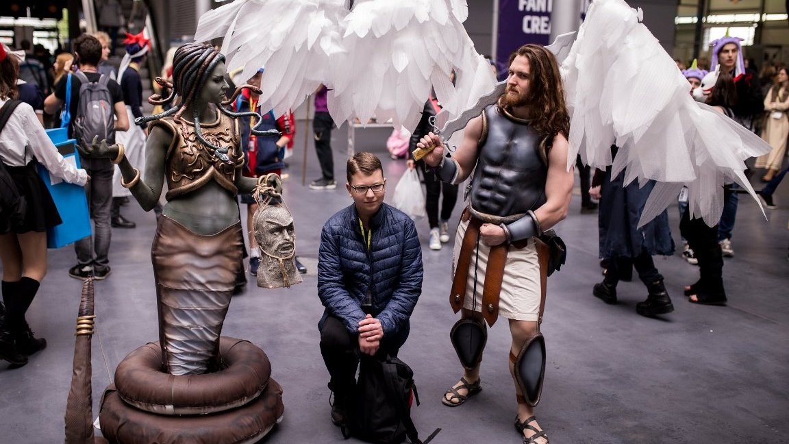 A young man standing between two people in disguise