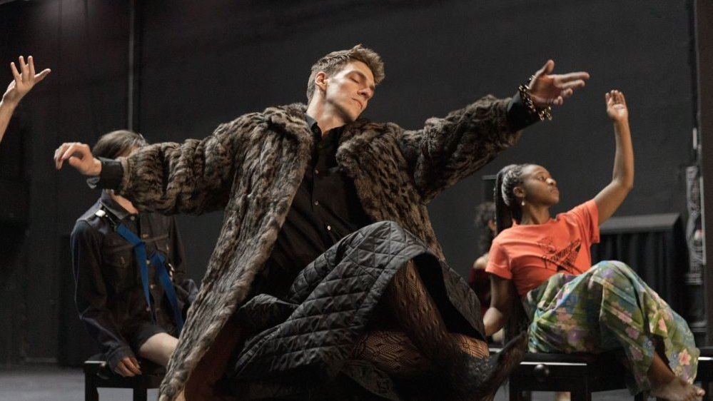 A scene from the performance - a few people on stage in various poses.