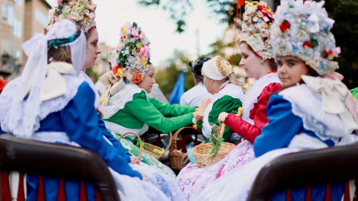 Photo af a few women in traditional national costumes with decorative headgears