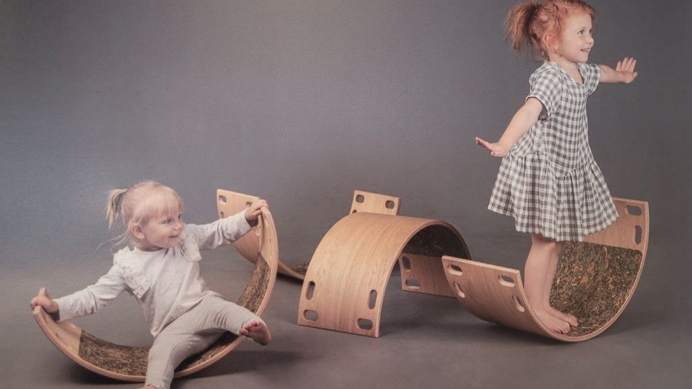 One of the exhibition works - a picture of two girls (one sitting and one standing) swinging on two wooden objects.