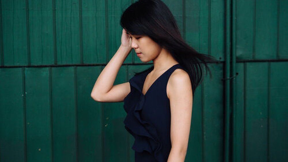 Photo of Kate Liu on a green background.