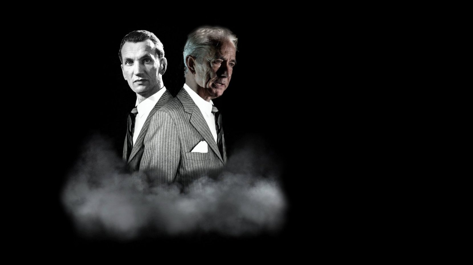 Black and white performance poster - photo of two men in suits on a black background.