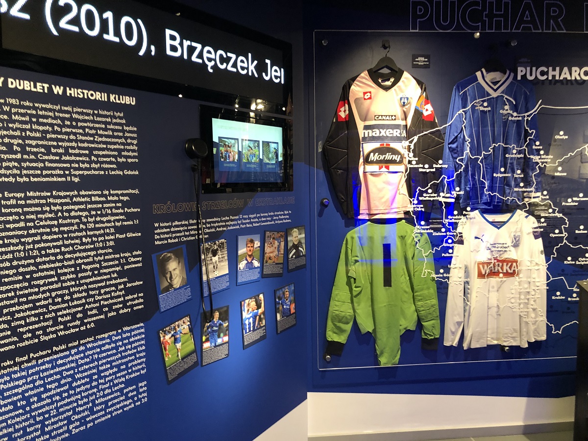 Photo of the exhibits: players' shirts, monitor, photos and text on the wall. - grafika artykułu