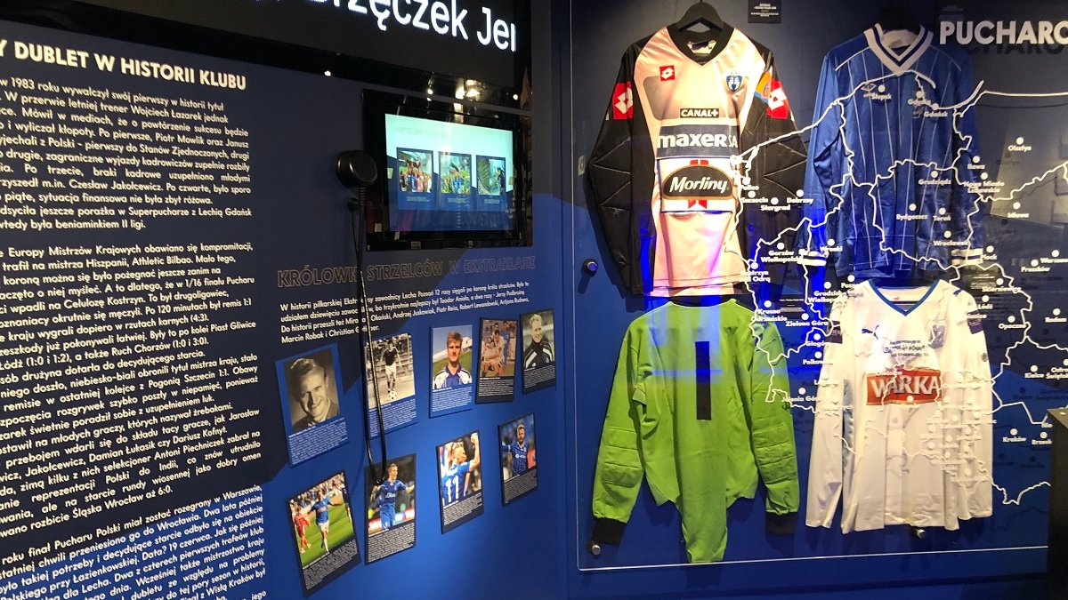 Photo of the exhibits: players' shirts, monitor, photos and text on the wall.