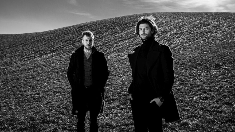 Black and white photo of Andrzej Ciepliński and Tymoteusz Bies - two young men standing on a field.