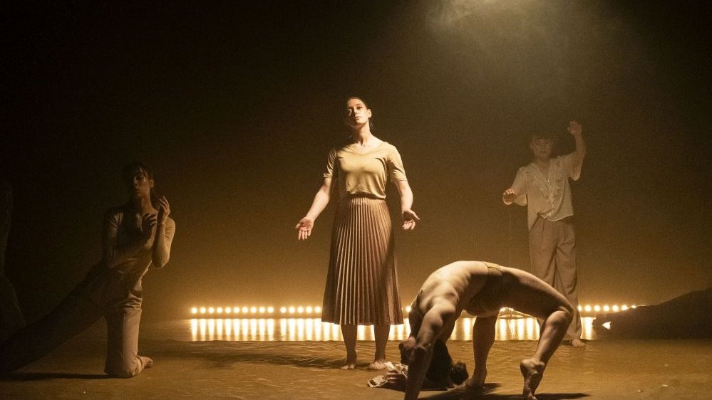 Four dancers in various poses. Photo in brown colours.
