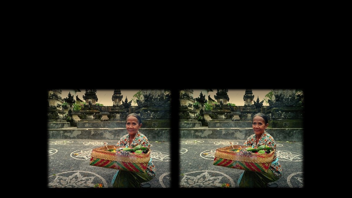 Stereophotograph of a woman carrying a colourful basket with flowers. A stony monument as a background.