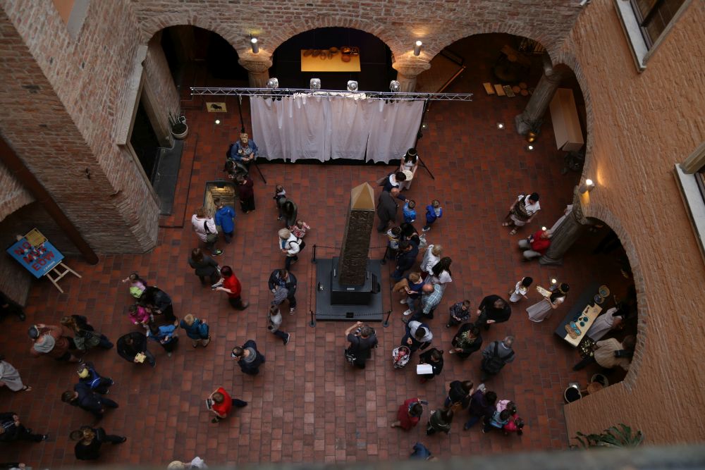 Bird's eye view - people in the courtyard of the Archaeological Museum, in the center of which stands a historic obelisk - grafika artykułu