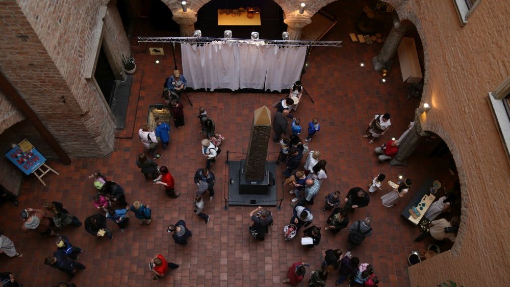 Bird's eye view - people in the courtyard of the Archaeological Museum, in the center of which stands a historic obelisk