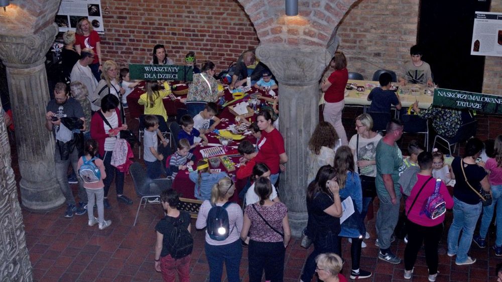 People in the courtyard of the Museum - children at tables making art works.