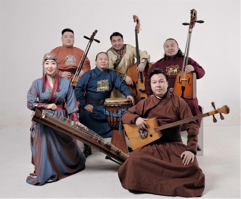 Five men and one woman in traditional Mongolian folk costumes pose with instruments. - grafika artykułu