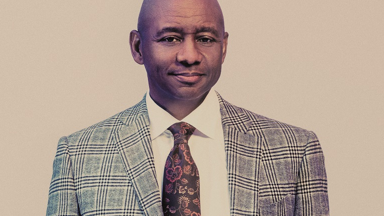 Photo of Branford Marsalis, standing with one of his hands in a trousers pocket.