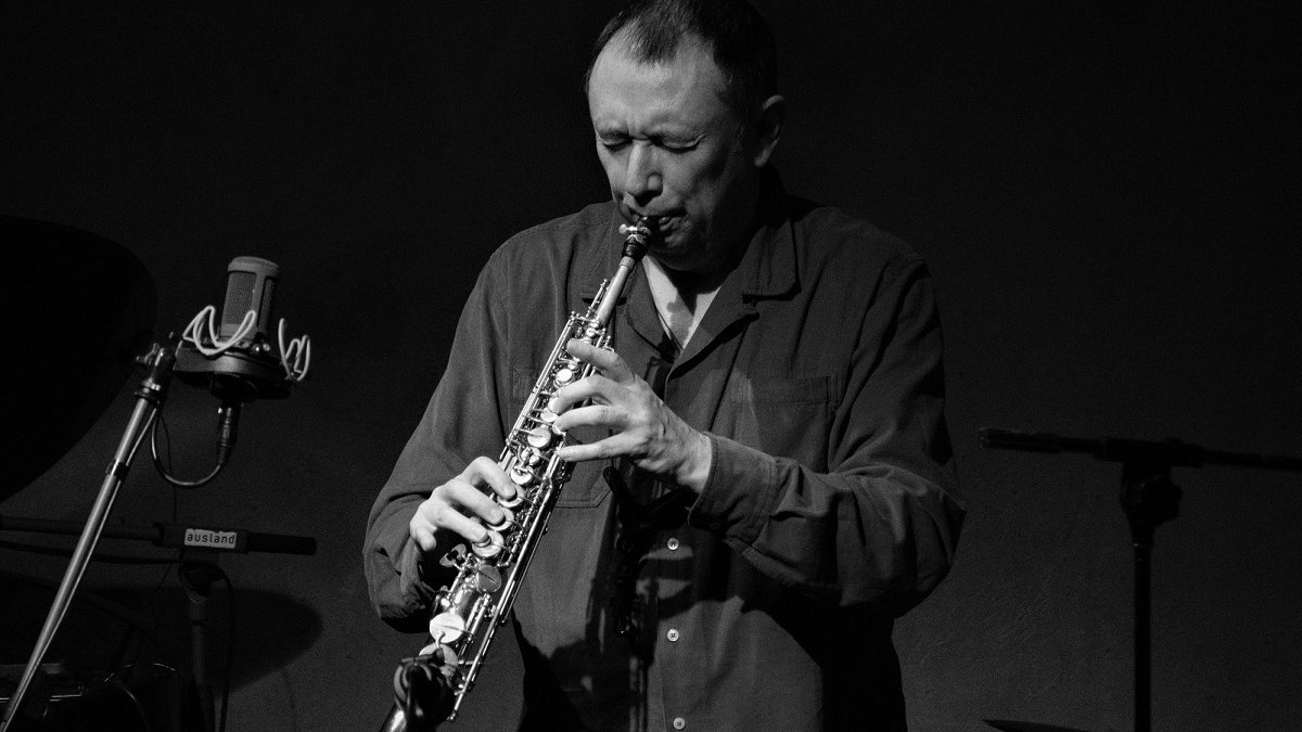 Black and white photo of John Butcher, playing the clarinet.