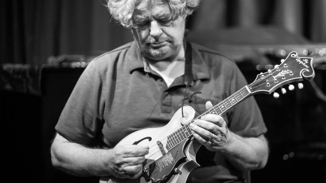 Black and white photo of a man playing the guitar.