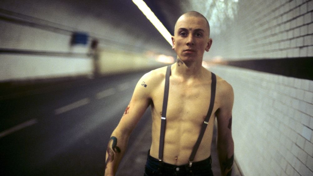 A young boy with a bare torso and suspenders marches bravely through an underground tunnel.