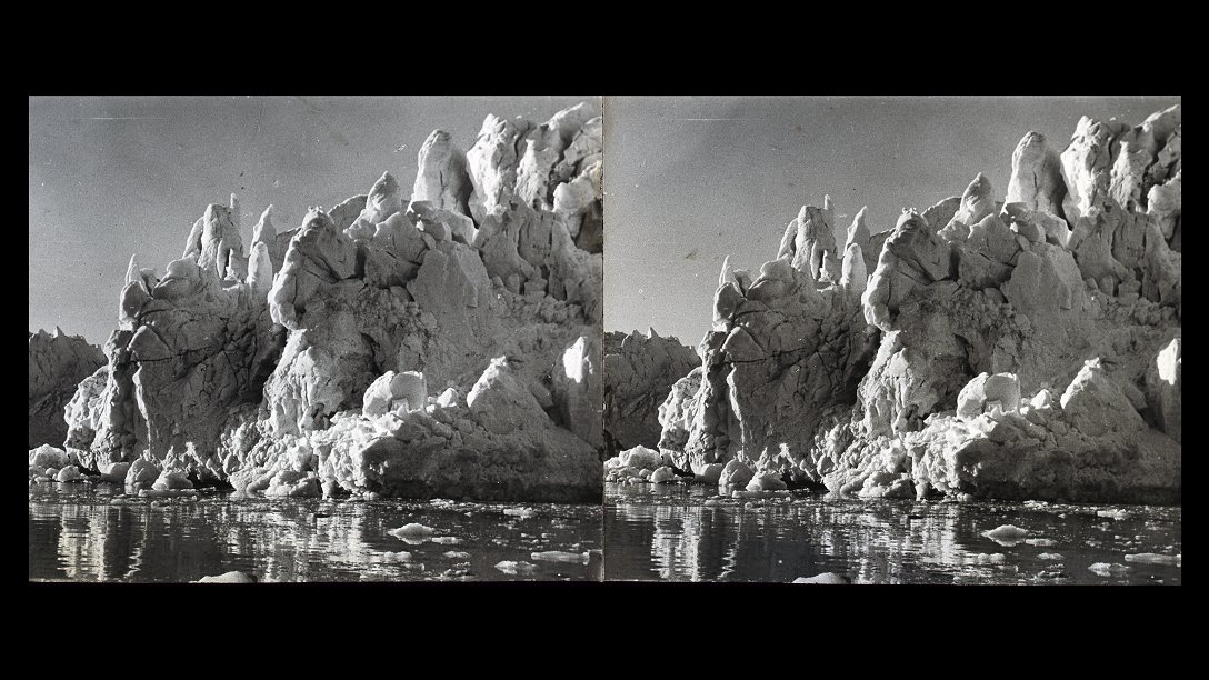 A fragment of a glacier with sharp peaks, with sea water at its foot.