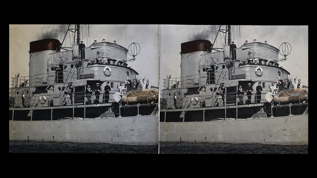 Part of the ship and the people standing on the deck, some of them waving goodbye.