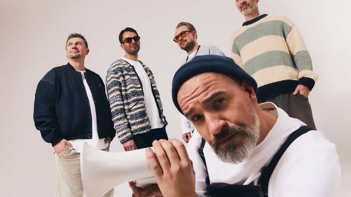 Five men, one of them, in front of the other four ones, is holding a megaphone.