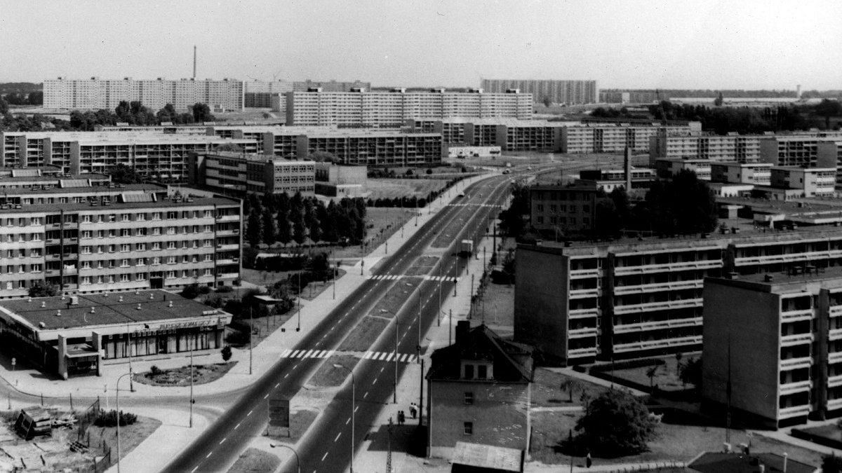 Black and white photo of housing estates with a street between them.