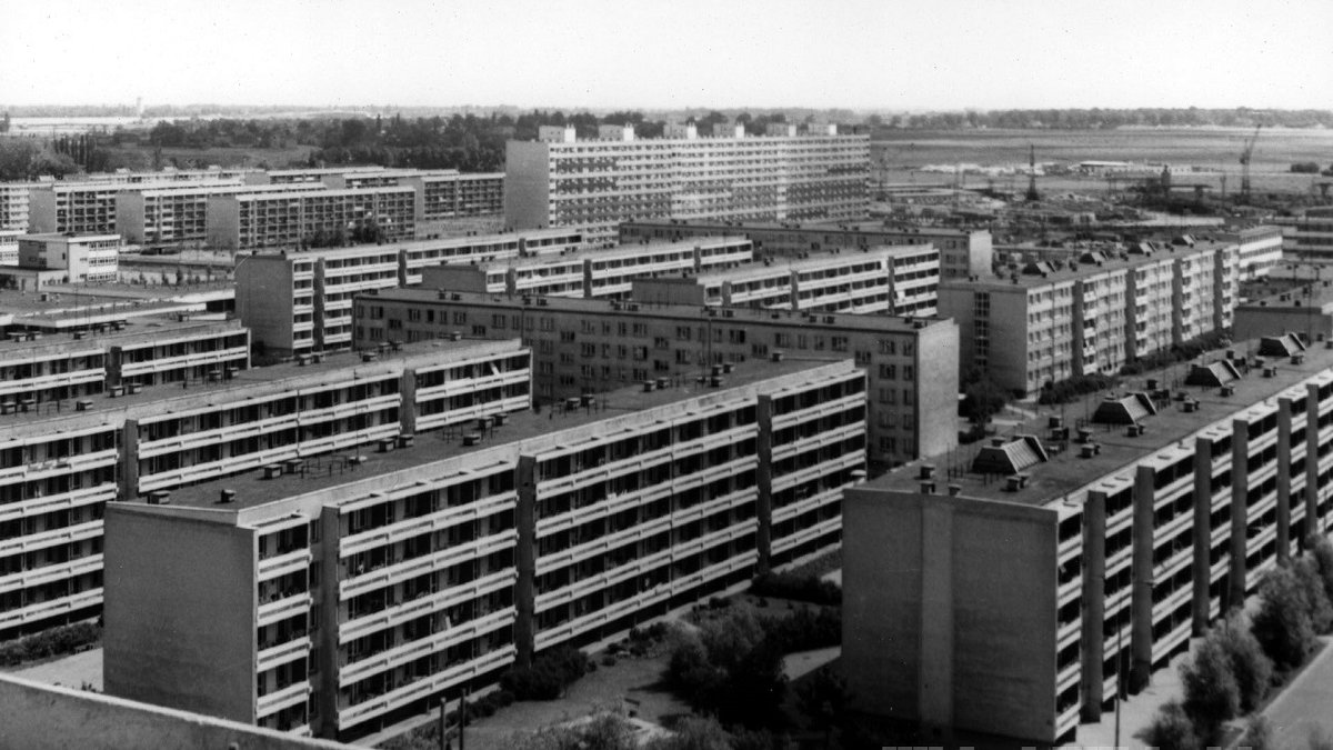 Black and white aerial photo of a housing estate, with buildings parallel to each other.