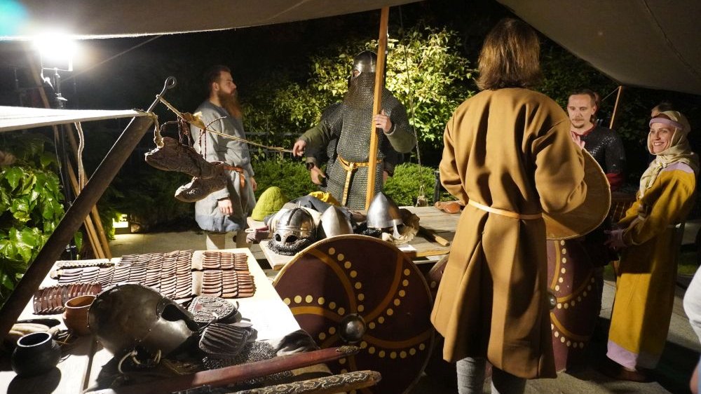 Several people in medieval warrior costumes with various accessories such as a helmet, shield and sword