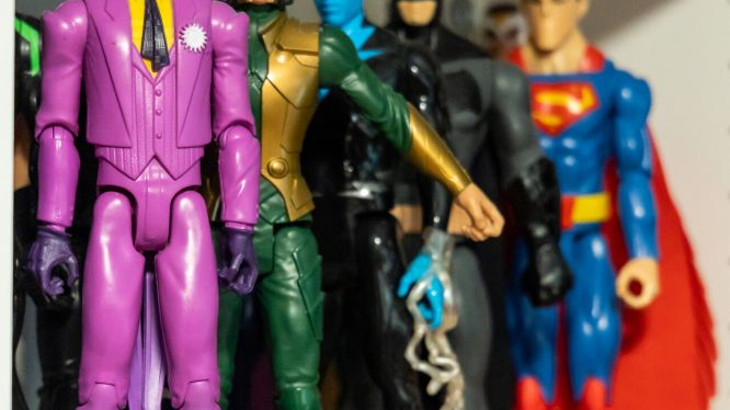 Colorful figures depicting The Joker in a purple suit, Loki in a golden helmet, Vision, Batman and Superman.