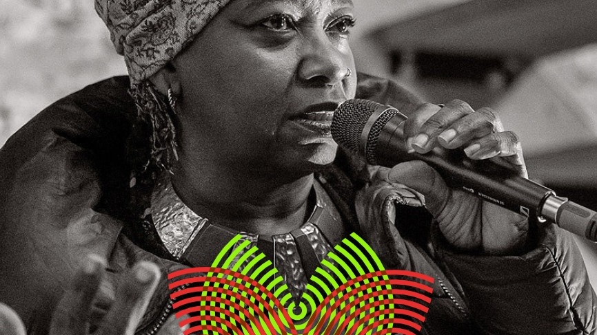 Black mature woman wearing a turban on her head and a rich ethnic necklace. Black and white photo.