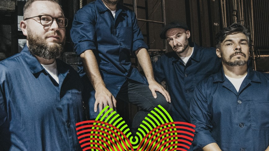 Four men, all dressed in navy blue, look seriously at the camera.