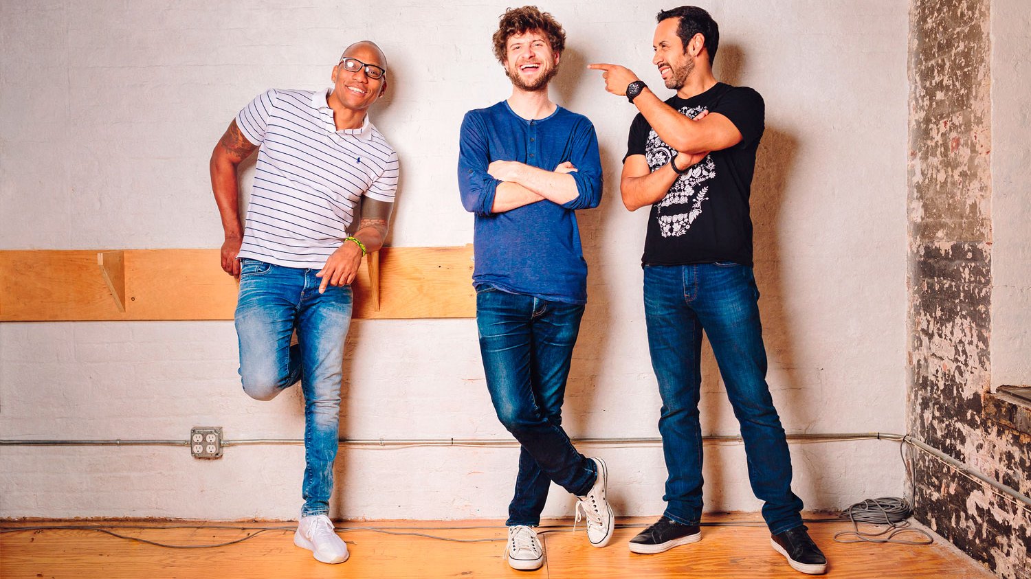 Three smiling men in various poses.