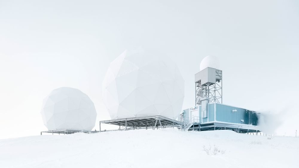 The white research building amidst the snow gives the impression of merging with the winter sky.
