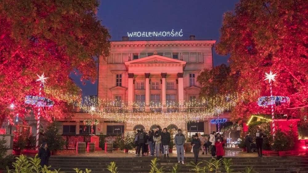The colorfully illuminated Arkadia building at Wolności Square with various Christmas decorations.