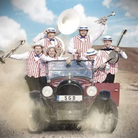 Photo of 6 men in an old car on a desert, dressed in white shirts, white and red vests and white hats, holding musical instruments in their hands.