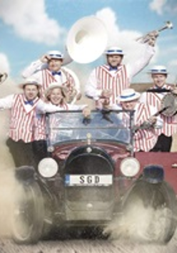 Photo of 6 men in an old car on a desert, dressed in white shirts, white and red vests and white hats, holding musical instruments in their hands.