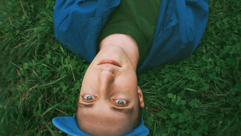 Photo of a man laying on the grass.
