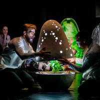 Photo from the performance: a man and a woman holding half of a structure resembling a big egg.