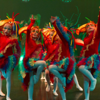 Photo of children in colourful clothes performing on stage.