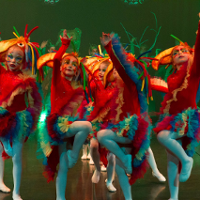 Photo of children in colourful clothes performing on stage.
