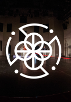 Photo of four people on stage. In the foreground, a white graphic sign in the shape of a circle.