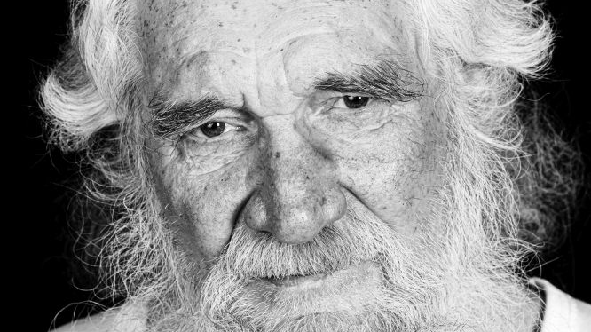 Black and white picture of an elderly man's face with grey hair and grey beard