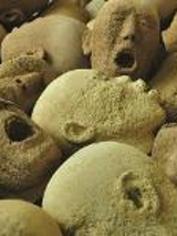 Photo of stone heads with open-mouthed faces